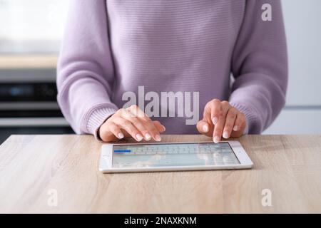 Hands on digital tablet keyboard close up girl working office work remotely typing text, woman using notepad computer Distance learning online Stock Photo
