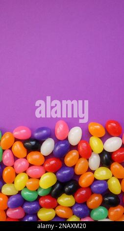 Colorful jelly beans on a purple background for Easter. Stock Photo