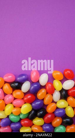 Colorful jelly beans on a purple background for Easter. Stock Photo