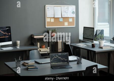 Part of openspace office with workplaces of economists or brokers analyzing stock market and illustrating its development by graphs Stock Photo