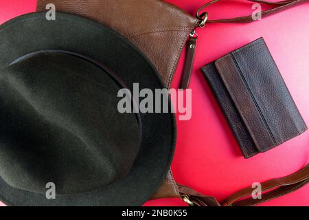Leather bag with felt hat and leather wallet on a red table top Stock Photo