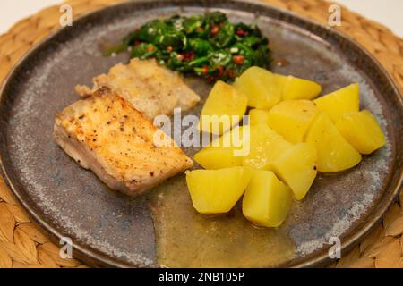 Healthy omega-3 rich salmon, nutrient-packed spinach, classic salty potatoes on a table Stock Photo