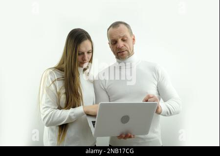 teacher female student laptop Focused woman trainee listening serious teacher mentor businessman explaining online strategy looking at laptop teaching trainees learning new skills in workplace Stock Photo