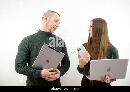 Interview of happy smiling manager with latin young professional and friendly support discussing job cv. Mentoring Hispanic male teacher and female student in multiethnic creative apple Ukraine 2023 Stock Photo