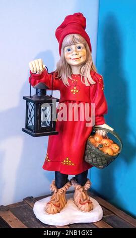 Sculpture of a Swedish girl holding a lantern in one hand and a basket of apples in the other at the Gammelgarden Museum in Scandia, Minnesota USA. Stock Photo