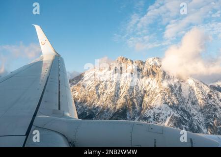 TUI plane passing mountains approaching Innsbruck airport, Austria Stock Photo