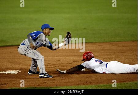 Dominican Republic's Freddy Guzman, right, is tagged out by