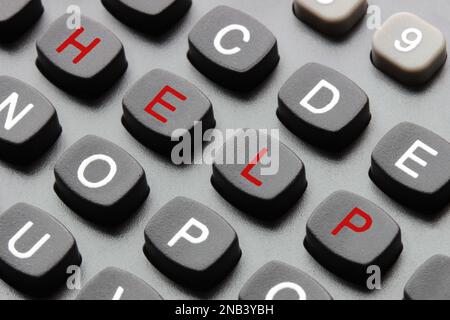 Macro view of a keypad with red letters spelling out the word HELP diagonally, concept for support and emergency call Stock Photo
