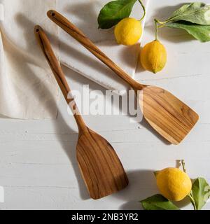 wooden spatulas with lemons on white table Stock Photo