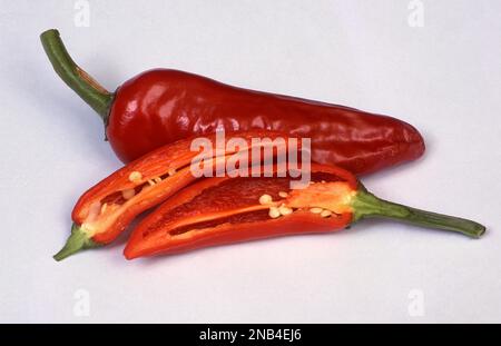 STUDIO IMAGE OF FULL AND SLICED RED CHILLI PEPPERS Stock Photo