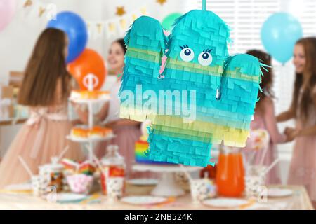 Bright festive pinata hanging indoors at birthday party Stock Photo