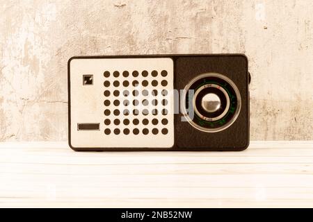 Old turntable. Several vinyl records and blossoming lilies against a background of black and white pine boards. Stock Photo