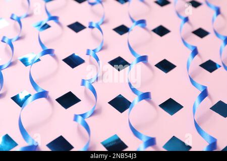 Shiny serpentine streamers on lilac background, closeup Stock Photo - Alamy