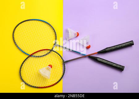 Rackets and shuttlecocks on color background, flat lay. Badminton equipment Stock Photo