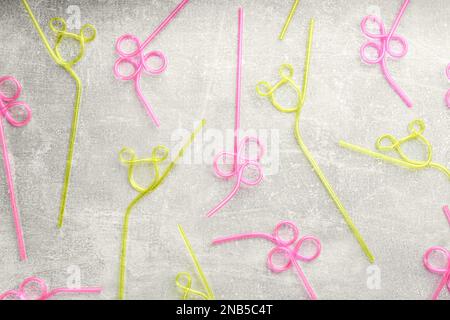 Colorful plastic drinking straws on grey stone table, flat lay Stock Photo