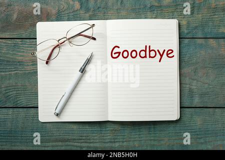 Notebook with word Goodbye on wooden table, top view Stock Photo