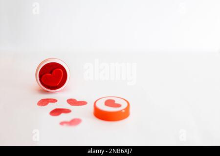 A stamp, in the shape of a red heart, next to ink marks, isolated on a white background. Stock Photo