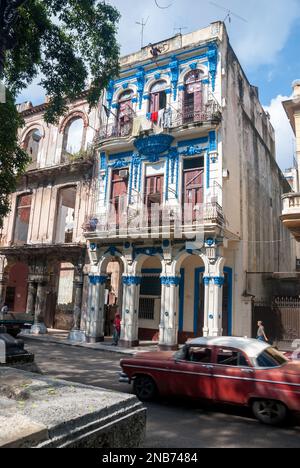 A vintage American automobile passes one of the many Spanish Colonial inspired buildings on the Prado in downtown Havana Stock Photo