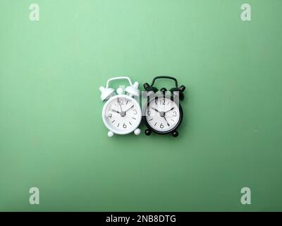 Top view Black and white alarm clock on a green background Stock Photo