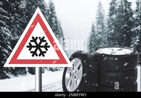 Set of wheels with winter tires and road sign outdoors Stock Photo