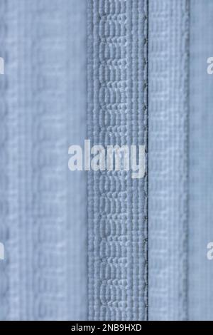Defocused macro abstract texture background of a fabric vertical blinds surface in a light blue color Stock Photo