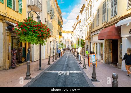 A picturesque street through the old town center of Antibes, France, in the Cote d'Azur, French Riviera region along the Mediterranean Sea. Stock Photo