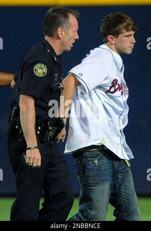 Baltimore City police officer Craig Singleterry, Sr., escorts Denver Broncos  cornerback Deltha O'Neal from the field after he was ejected for bumping an  official during a game against the Baltimore Ravens, Monday