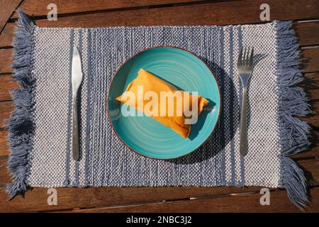 Hallaca or Tamale over a rustic table and a blue dish, Mexican and Venezuelan traditional food Stock Photo