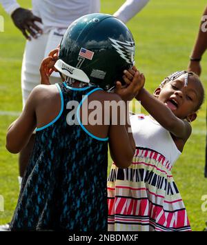 Philadelphia Eagles quarterback Michael Vick's daughter Jada Vick, 6, left,  plays with her father's helmet and her sister London Vick, 3, after an NFL  football training camp practice at Lehigh University Friday