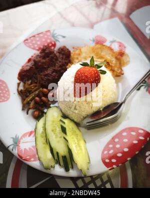 Fresh strawberry on the Nasi Lemak. Special chillies gravy cooked with strawberries. Stock Photo