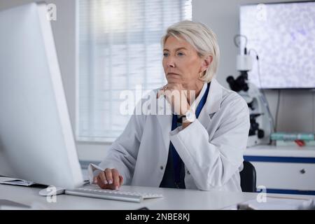 Science, computer and female scientist working on research, experiment or test for a project in lab. Technology, professional and senior woman Stock Photo