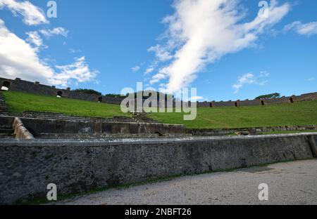 A view of the stone, grass covered amphitheater on a moody day. At Pompeii Archaeological Park near Naples, Italy. Stock Photo