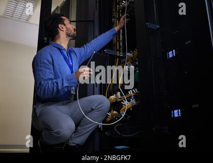 Tablet, server room and engineer with connection cable for maintenance or software update at night. Cybersecurity wire, programmer and it man holding Stock Photo