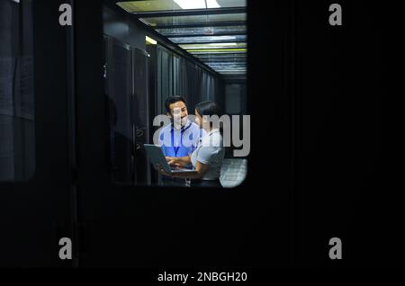 Man, woman or laptop in server room, IT engineering or software programming for cybersecurity, analytics or database safety. Smile, happy or data Stock Photo