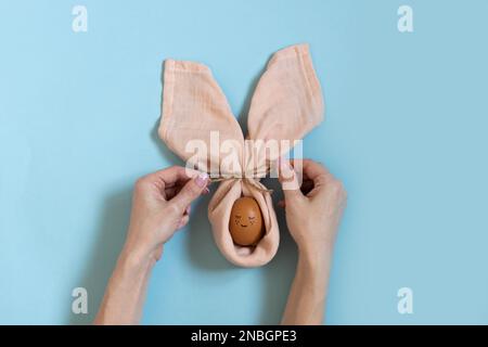 Happy easter table decoration. Easter painted egg bunny. Cute and funny rabbit. Handmade easter table setting with hands. Scandinavian style. Craft, d Stock Photo