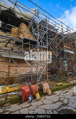 Preservation, restoration work with metal scaffolding being done at a two story villa building. At Pompeii Archaeological Park near Naples, Italy. Stock Photo