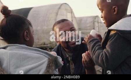 Country life is everything that its cracked up to be. a man working with his adorable son and daughter on a chicken farm. Stock Photo