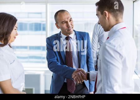 Handshake of two business partners communicating in the office at a corporate meeting Stock Photo