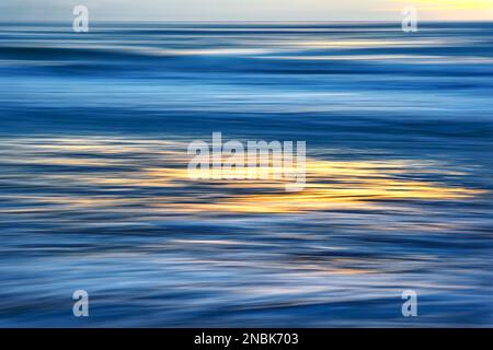 Ocean abstract at sunset. The picture is taken blurred by panning the camera. Blue and turquoise ocean waves. Stock Photo