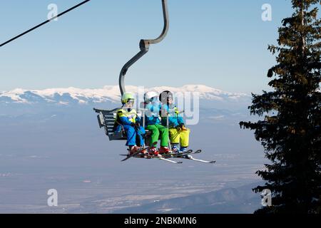 Children little skiers on ski lift in Vitosha Mountain above Sofia, Bulgaria, Eastern Europe, Balkans, EU Stock Photo