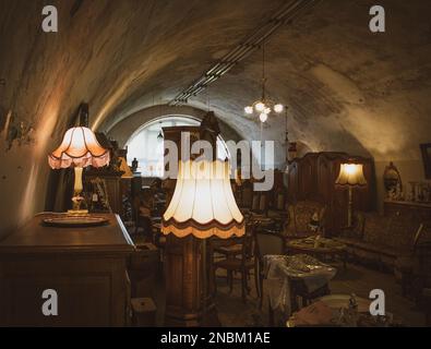 interior of an antiques store in dark colors with burning lamps in the foreground Stock Photo