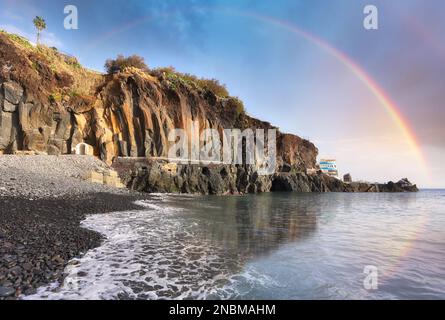 Ocean dramatic sunset with rainbow near natural pools in Madeira. Portugal Stock Photo