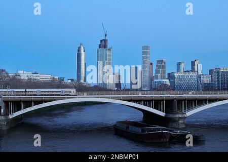 Train from Victoria station crosses the Grosvenor rail bridge over the river Thames at Chelsea, London, England, with Vauxhall skyscrapers in the back Stock Photo