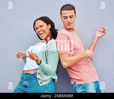 Dance, happy and playful couple with air guitar for comedy isolated on a grey studio background. Excited, crazy and interracial man and woman playing Stock Photo