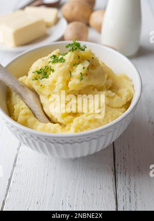 Mashed potatoes in a bowl on white background with space for text and ingredients for cooking Stock Photo