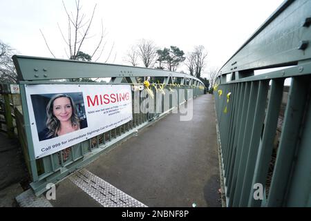 A missing person appeal poster for Nicola Bulley and yellow ribbons with messages of hope written on them tied to a bridge over the River Wyre in St Michael's on Wyre, Lancashire, as police continue their search for Ms Bulley, 45, who vanished on January 27 while walking her springer spaniel Willow shortly after dropping her daughters, aged six and nine, at school. Picture date: Tuesday February 14, 2023. Stock Photo