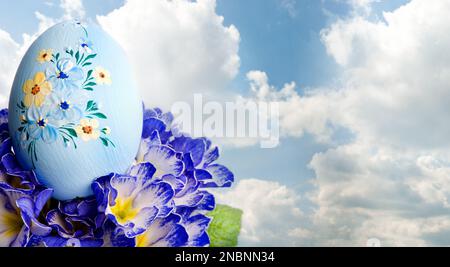 decorated blue Easter egg and spring flowers Stock Photo