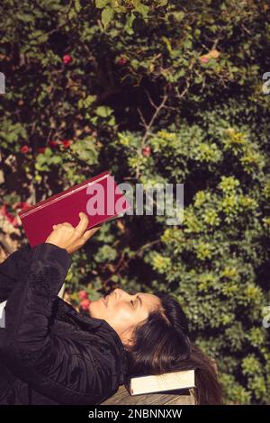 beautiful woman reading in the garden lying on wooden table Stock Photo