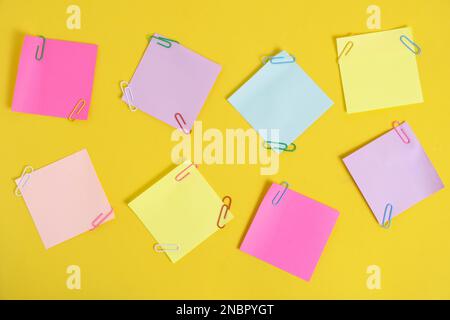 Colorful stickers for notes and paper clips yellow background Stock Photo
