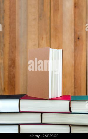 closed book on top of a stack of books placed in the form of a wall Stock Photo